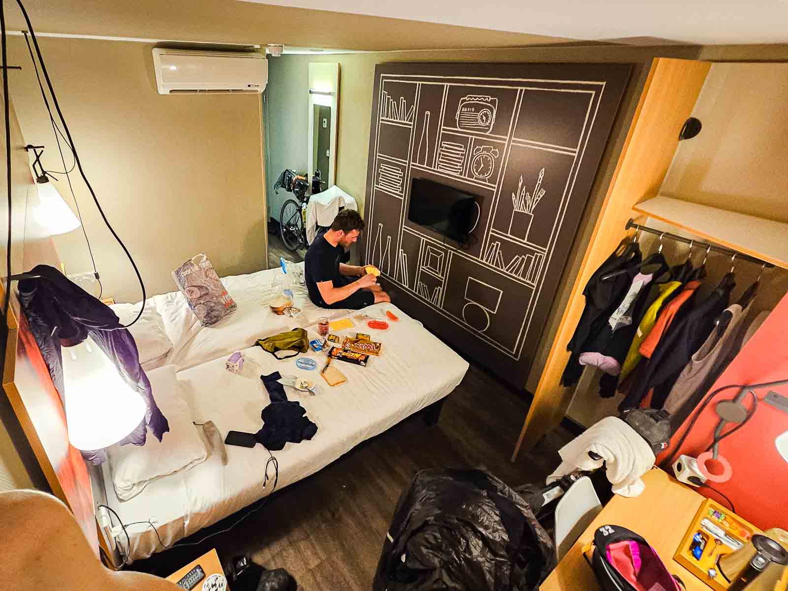 Ein Hotelzimmer zweier Teilnehmer des Race around the Netherlands ist vollgestellt mit Fahrrädern, Essen und Bekleidung