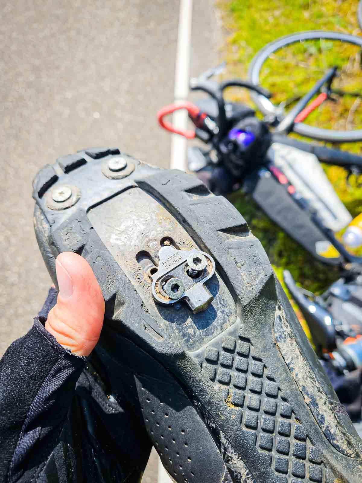 Eine lockere Cleatplatte mit losen Schrauben an einem Radschuh