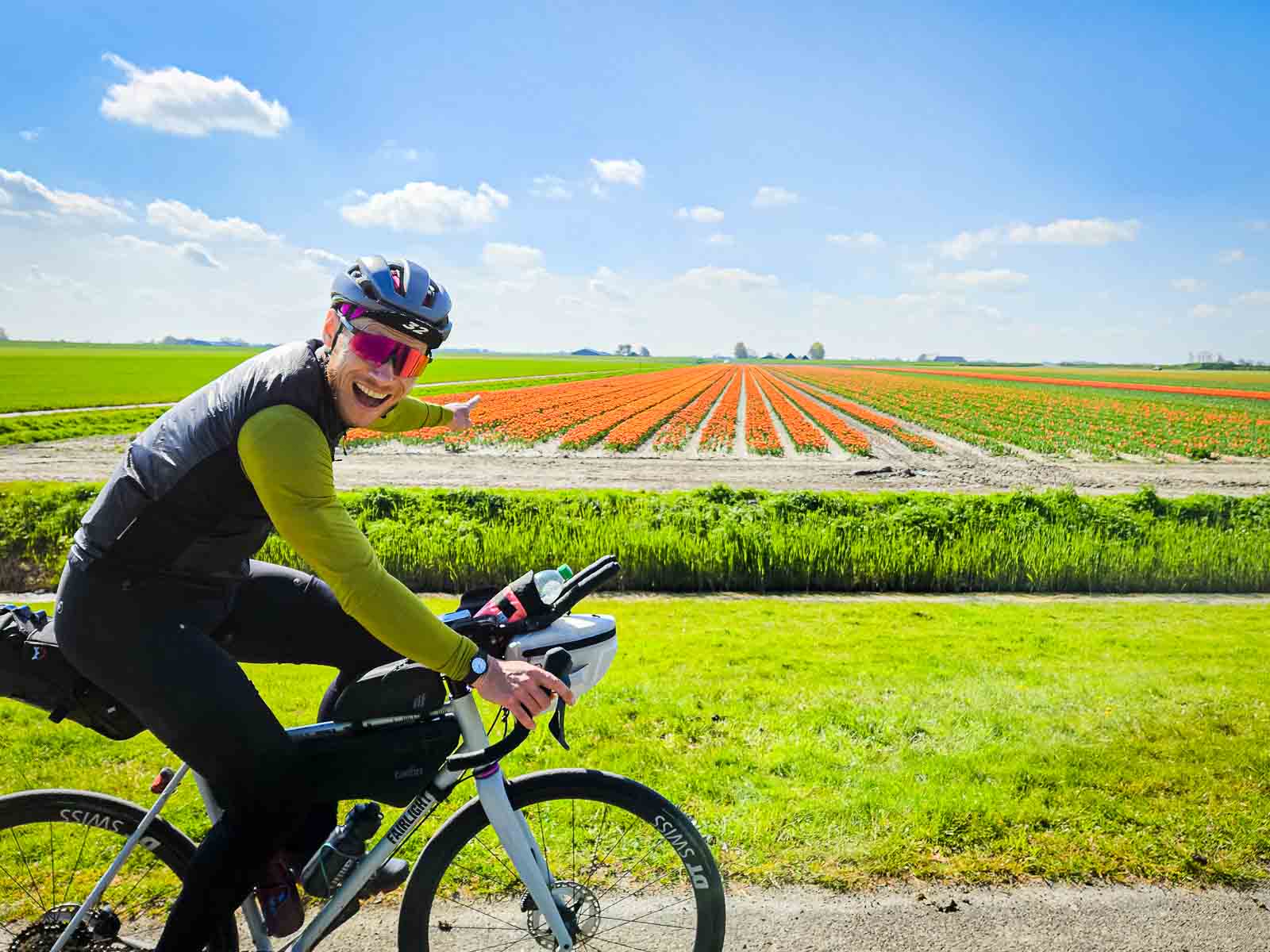 Ein Teilnehmer des Race arouund the Netherlands freut sich über den Anblick bunter Blumen und zeigt darauf
