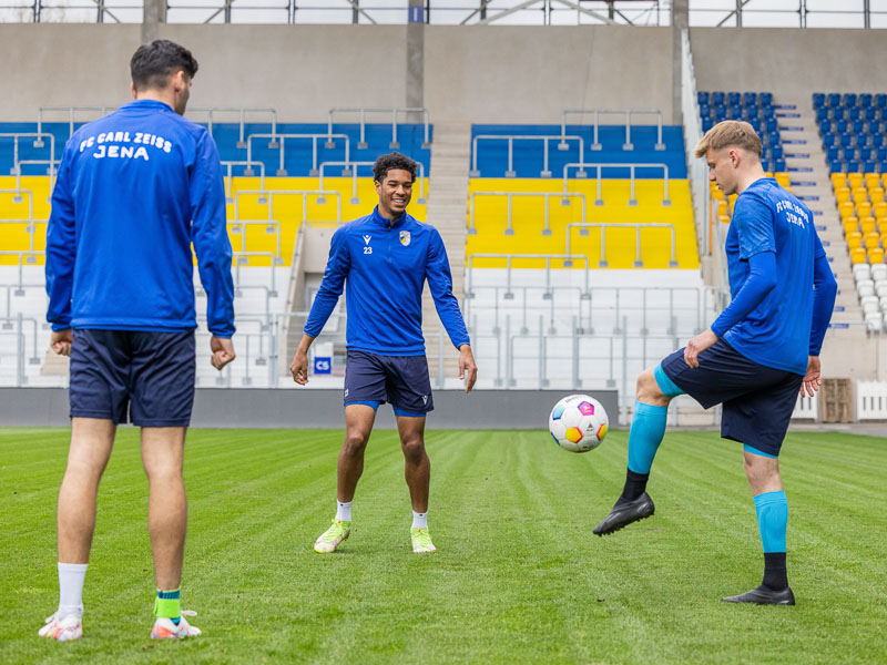 Drei Spieler des FC Carl Zeiss Jena im Stadion beim Training mit dem Fußball die verschiedene Produkte von Bauerfeind Sports tragen